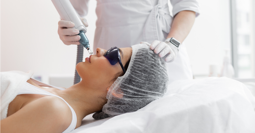 Woman wearing special eyewear while receiving facial skin treatment